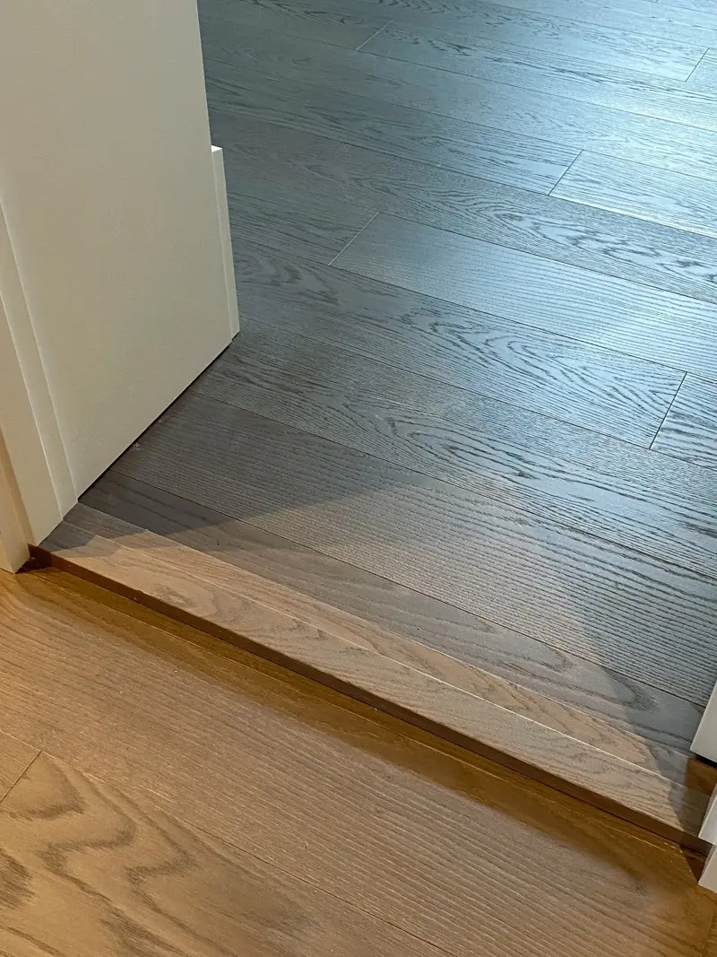 Lakkert eikegulv ved siden av nyslipt, ubehandlet tre